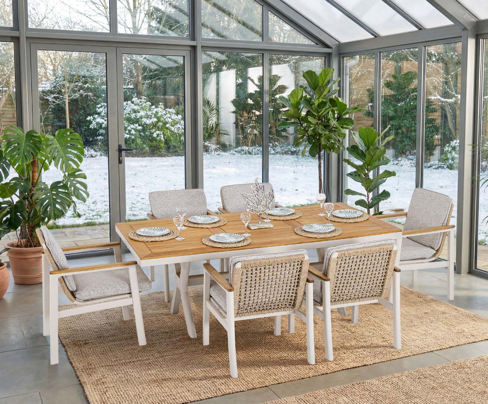 Lichte serre met een gedekte eettafel en stoelen van de Astoria-collectie
